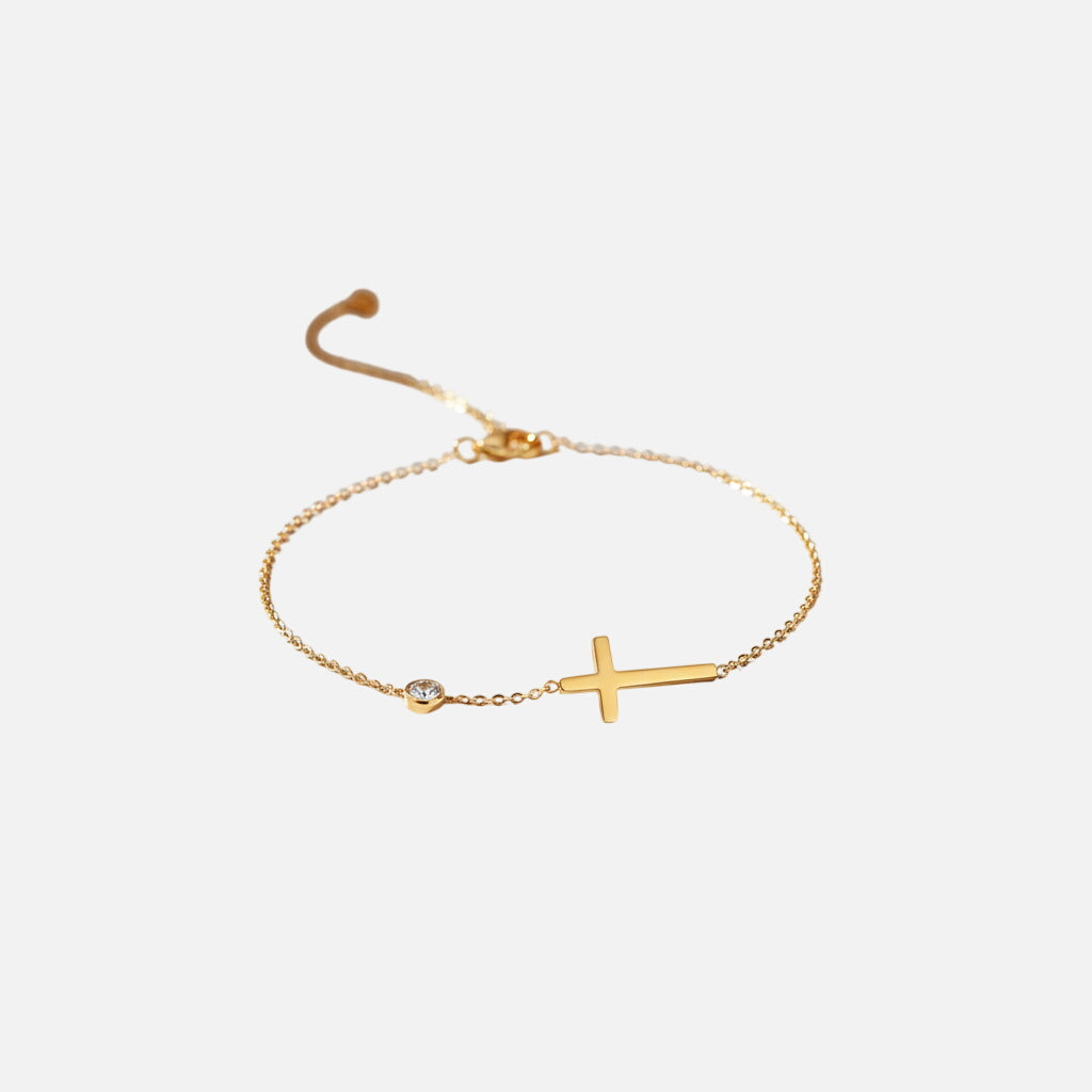 Gold cross bracelet flatlay